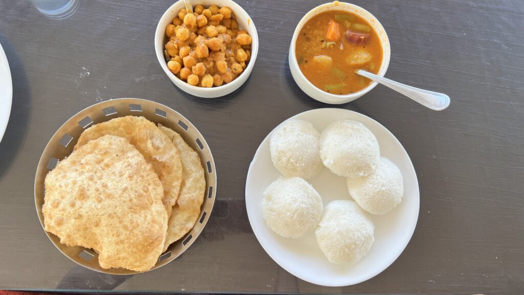 Breakfast at Lazo Golden Valley Resort, Munnar, with idli, poori, chickpea curry and sambar